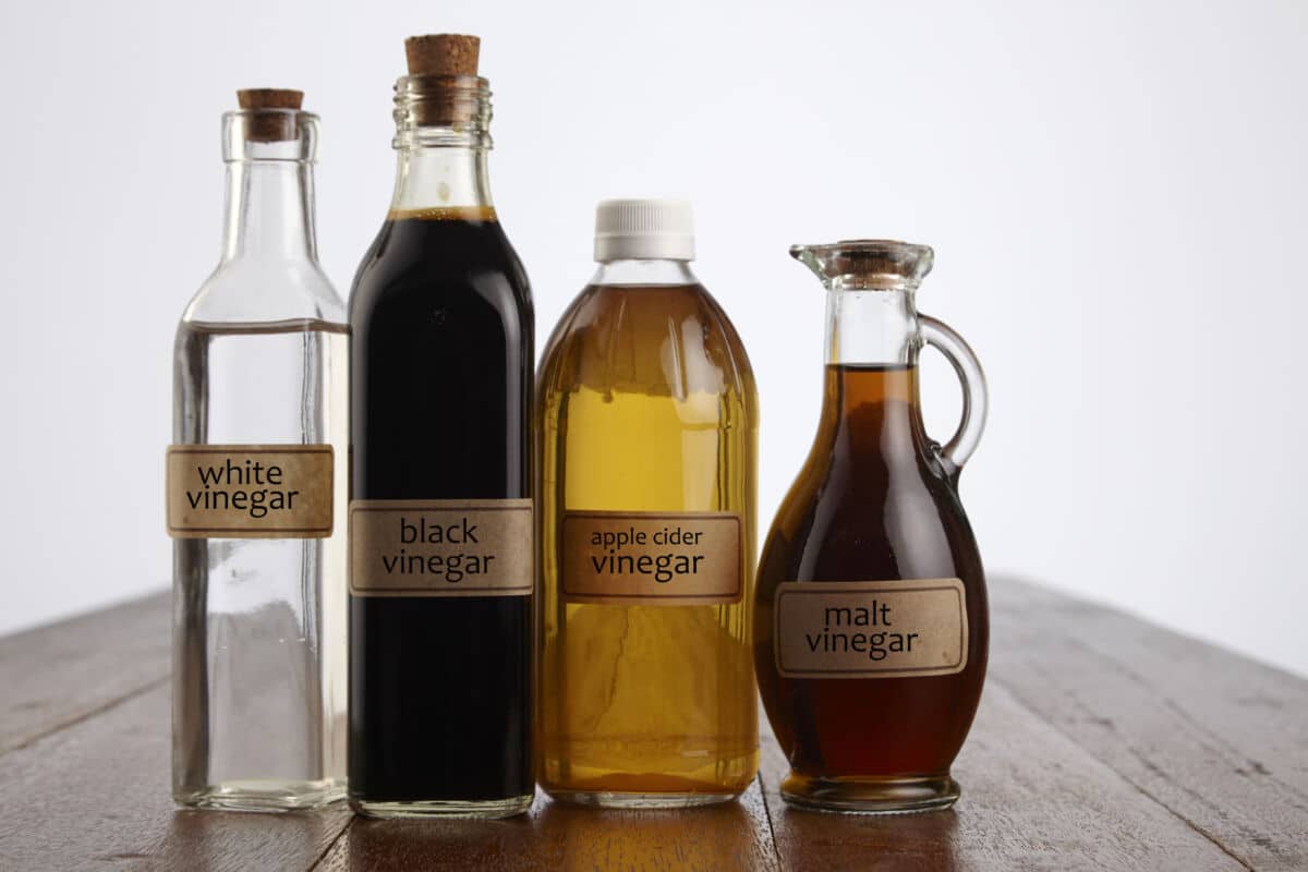 Various bottles of vinegar on a wooden table