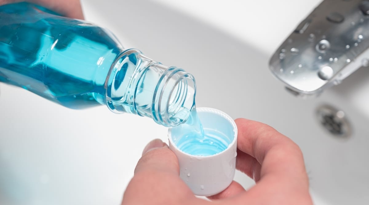 Pouring Mouthwash into a cup.